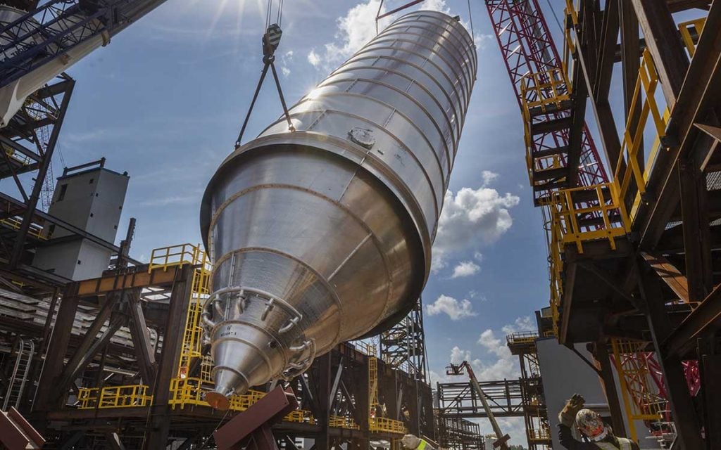 Large tank being lowered by a crane